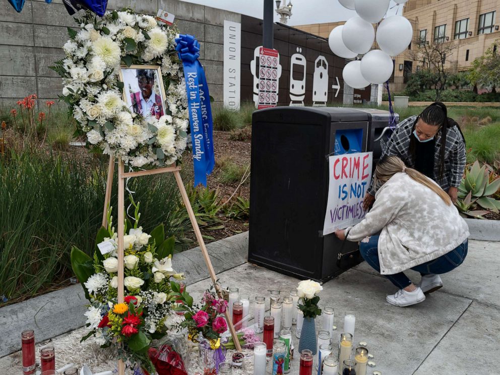 PHOTO: Nursing student Samantha Mesa hangs a sign in downtown Los Angeles on Jan. 19, 2022, with registered nurse Terri Thompson, right, in support of Sandra Shells at a memorial set up to her at the bus stop where she was attacked.
