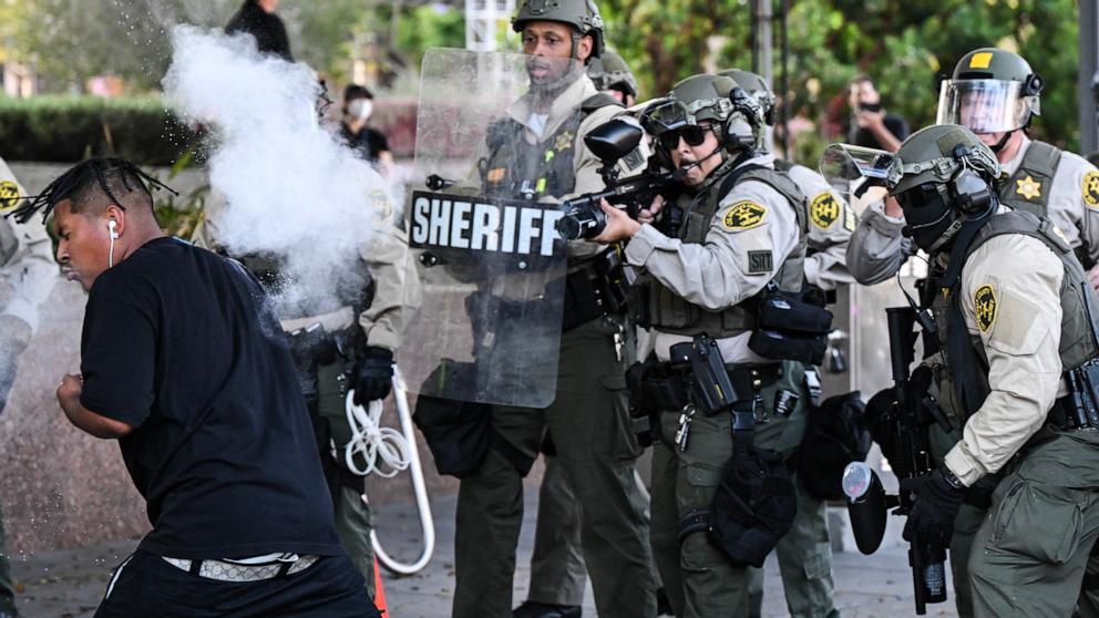 PHOTO: Los Angeles County Sheriff's Department deputies fire a nonlethal weapon toward a man after he threw a can at them following a protest against federal immigration operations near Los Angeles City Hall in Los Angeles on June 11, 2025.