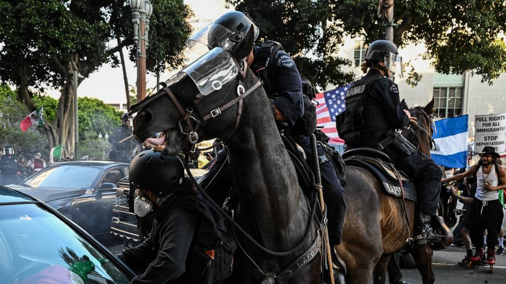 PHOTO: LAPD officers on horseback clash with protesters gathered near Los Angeles City Hall to protest against federal immigration operations on June 11, 2025.