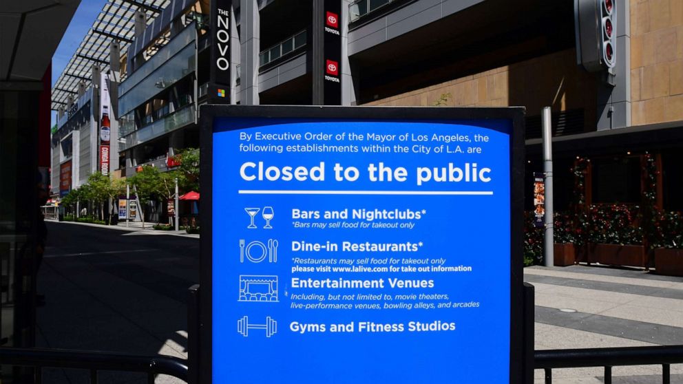PHOTO: In this file photo taken on May 7, 2020, a sign that's been in place since mid-March announces the temporary closures of restaurants, nightclubs, gyms and entertainment venues at LA Live in Los Angeles, California.