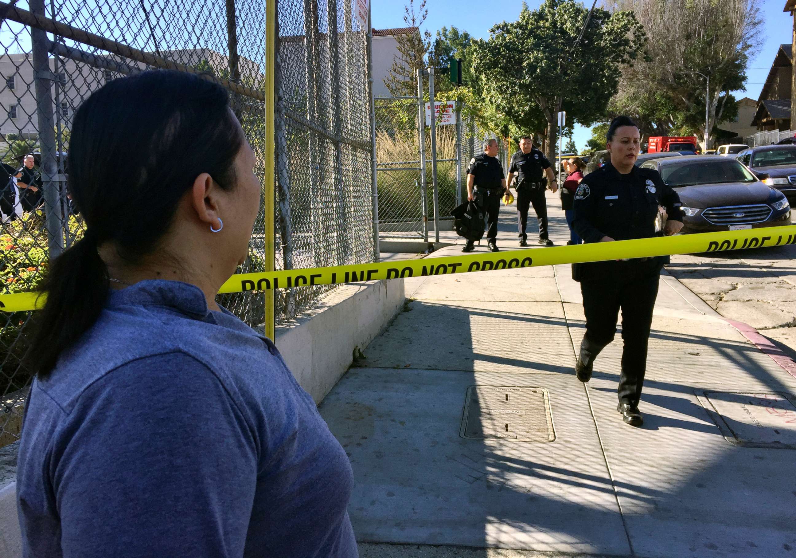 PHOTO: Gloria Echeverria watches as Los Angeles police officers close off a street where a shooting occurred at a middle school in Los Angeles, Feb. 1, 2018.