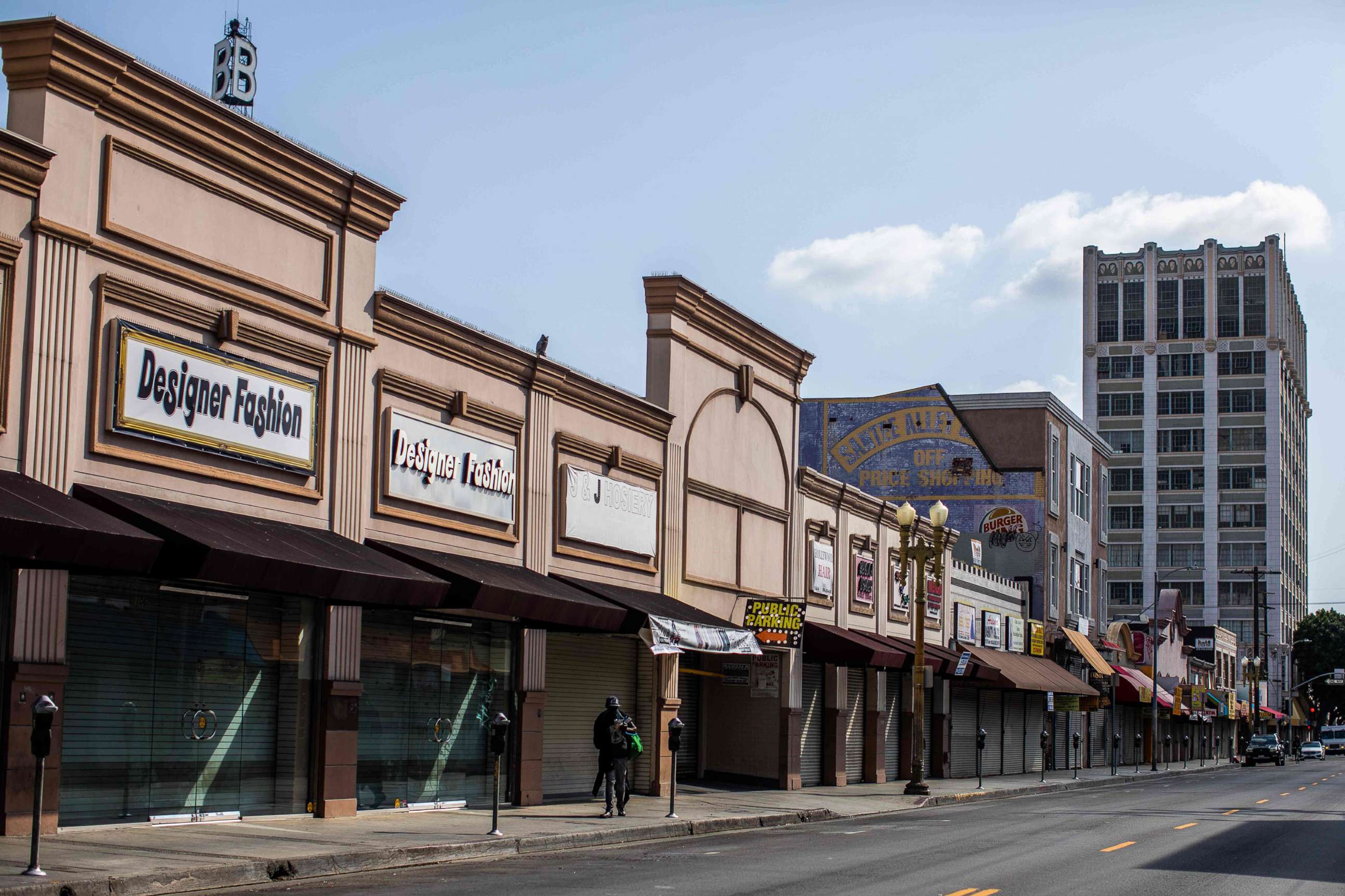 PHOTO: In this April 2, 2020, file photo, a homeless man walks past closed stores in the Fashion District in downtown Los Angeles.