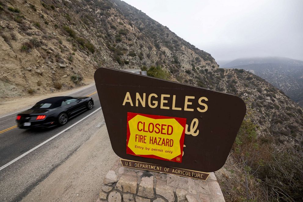 PHOTO: A car passes forest closure signage along the Angeles Crest Highway in the Angeles National Forest which, along with all national forests in California, is closed due to dangerous wildfire conditions, Sept. 2, 2021 near La Canada Flintridge, Calif.