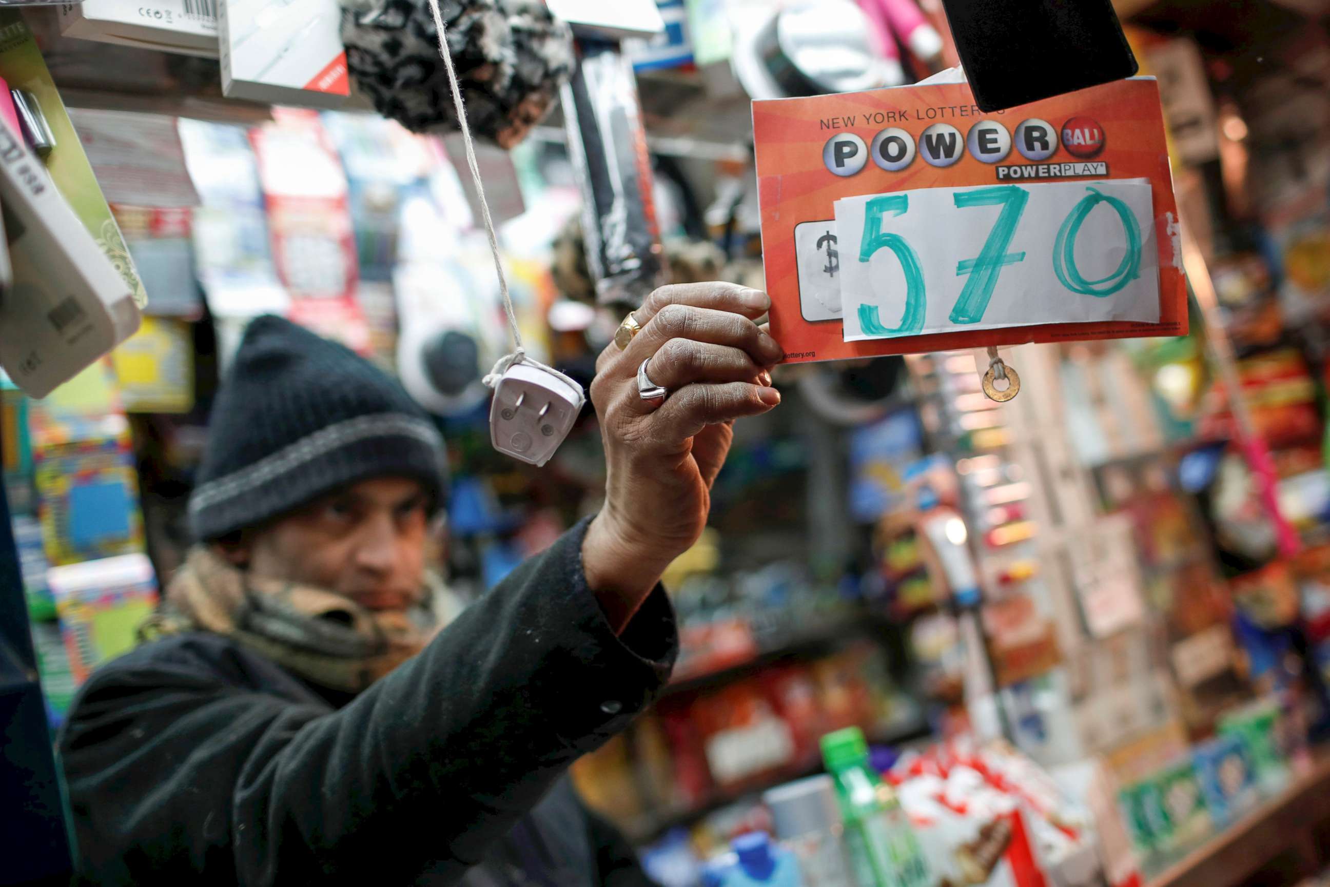 PHOTO: A vendor who sells lottery tickets hangs a sign for the Powerball drawing at a news stand in midtown Manhattan, Jan.  5, 2018.