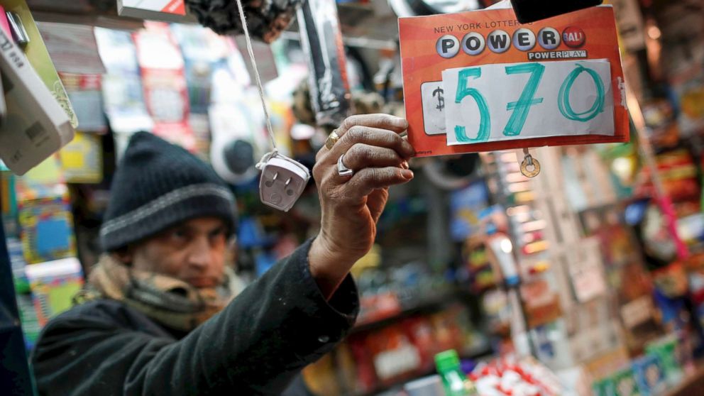PHOTO: A vendor who sells lottery tickets hangs a sign for the Powerball drawing at a news stand in midtown Manhattan, Jan.  5, 2018.