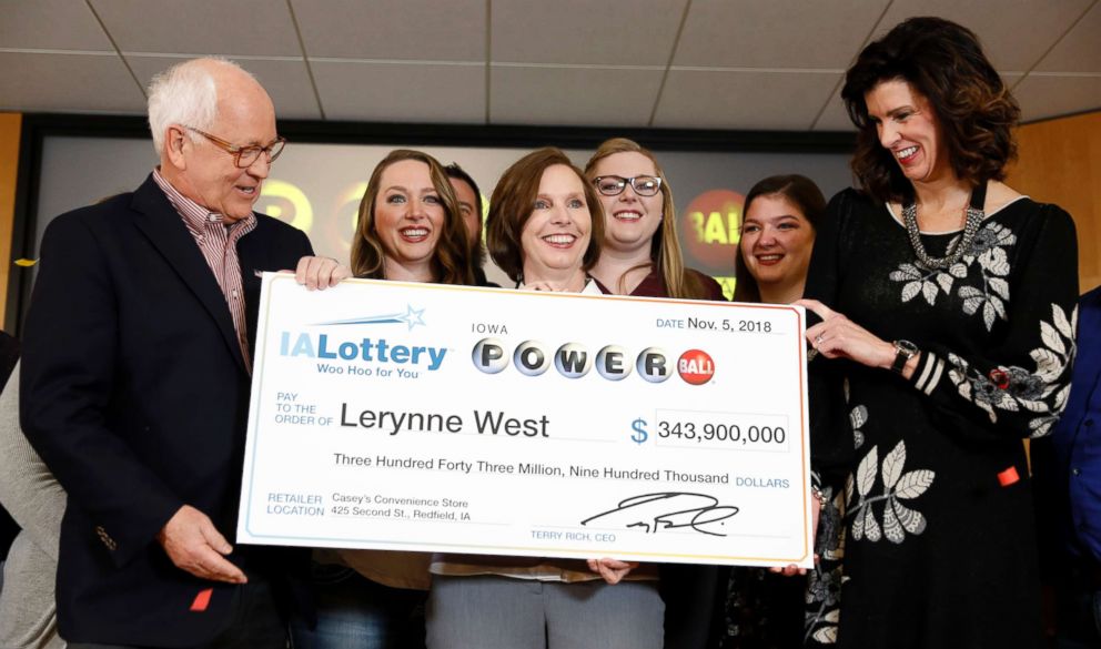 PHOTO: Iowa Lottery CEO Terry Rich, left, presents a check to Lerynne West, of Redfield, Iowa, center, for her share of a nearly $700 million Powerball prize, Monday, Nov. 5, 2018, at the Iowa Lottery headquarters in Clive, Iowa. 