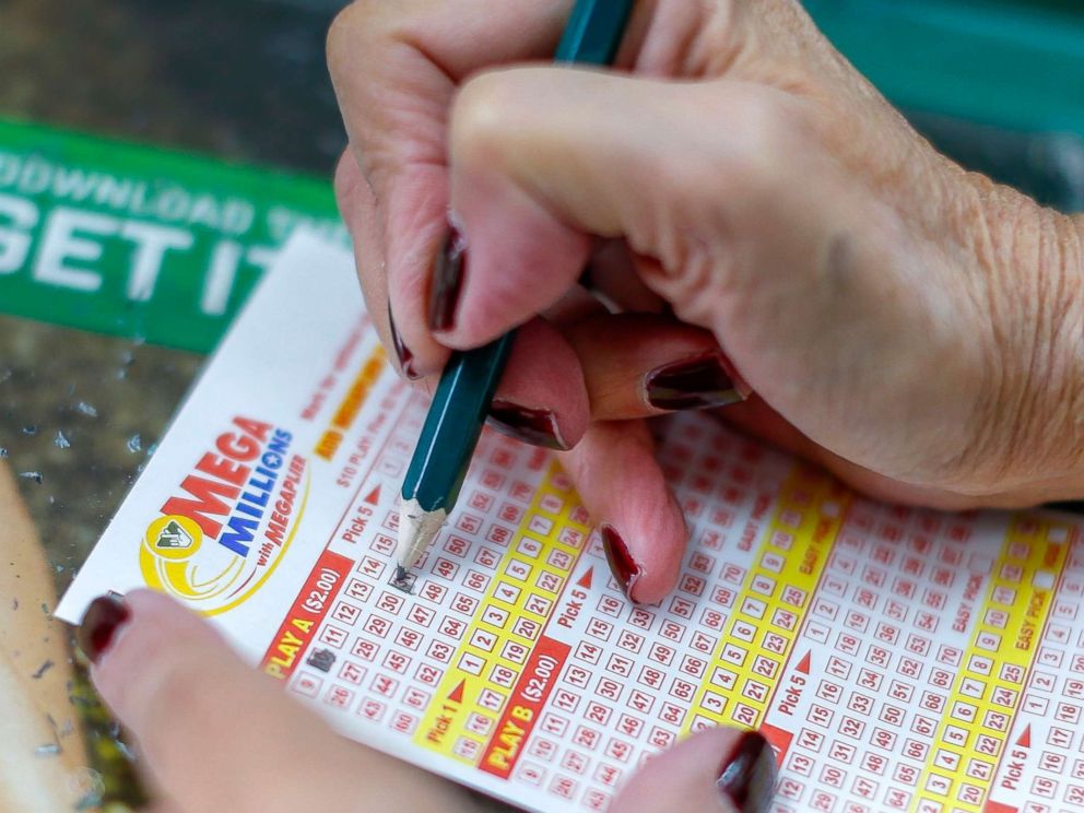 PHOTO: A customer fills out a game card before buying Mega Millions lottery tickets at a retailer in Arlington, Virginia on October 22, 2018.