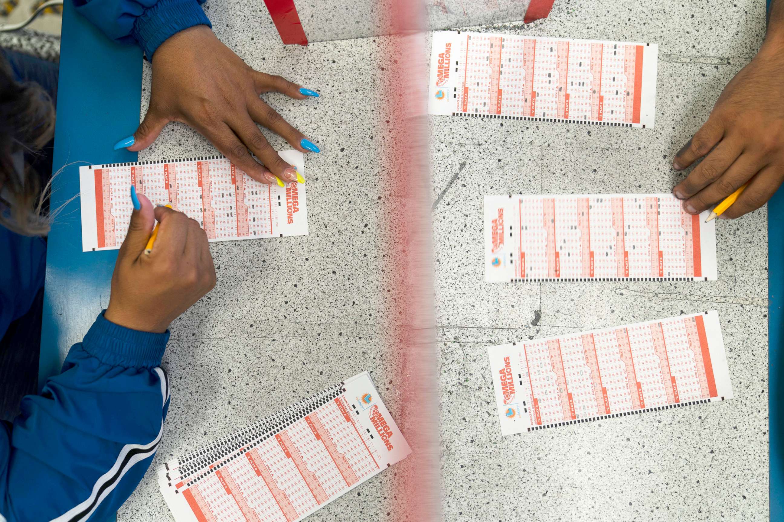 PHOTO: Nancy Linares, left, and Prince Joseph Israel fill out Mega Millions play slips at Blue Bird Liquor in Hawthorne, Calif., July 26, 2022.