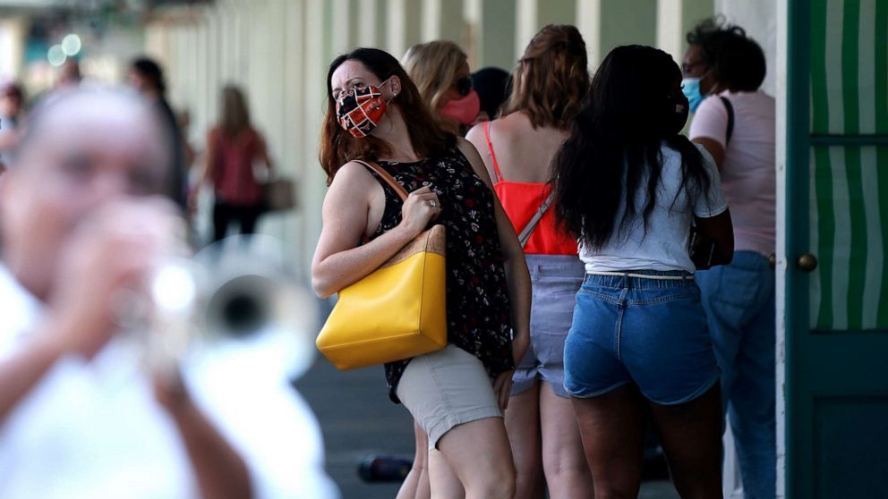 PHOTO: A woman waits in line for carryout at Cafe Du Monde in the French Quarter on July 14, 2020 in New Orleans.