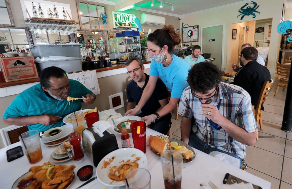 PHOTO: Waitress Gina Lauricella serves customers indoors, for the first time since the state shutdown, at Charles Seafood Restaurant in Harahan, La., May 15, 2020. 