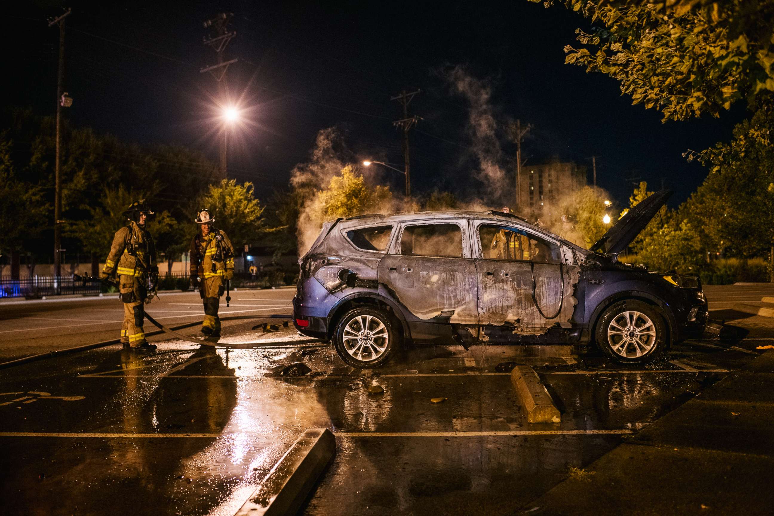 PHOTO: Firefighters stand next to a burned out car, Sept. 26, 2020, in Louisville, Kentucky.