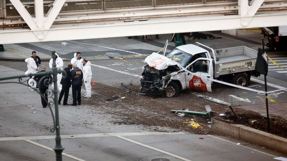 Authorities stand near a damaged Home Depot truck after a motorist drove onto a bike path near the World Trade Center memorial, striking and killing several people, Oct. 31, 2017, in New York.