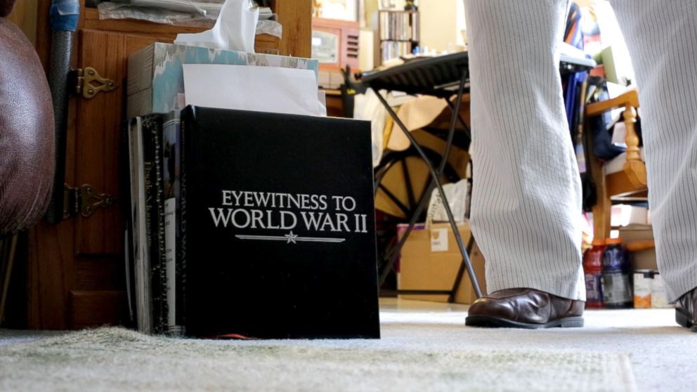 PHOTO: Leatherman stands next to a book on the ground of his apartment that is entitled "Witnesses of World War II". Leatherman was a mailman aboard the U.S.S. Oglethorpe in the Pacific Theater.
