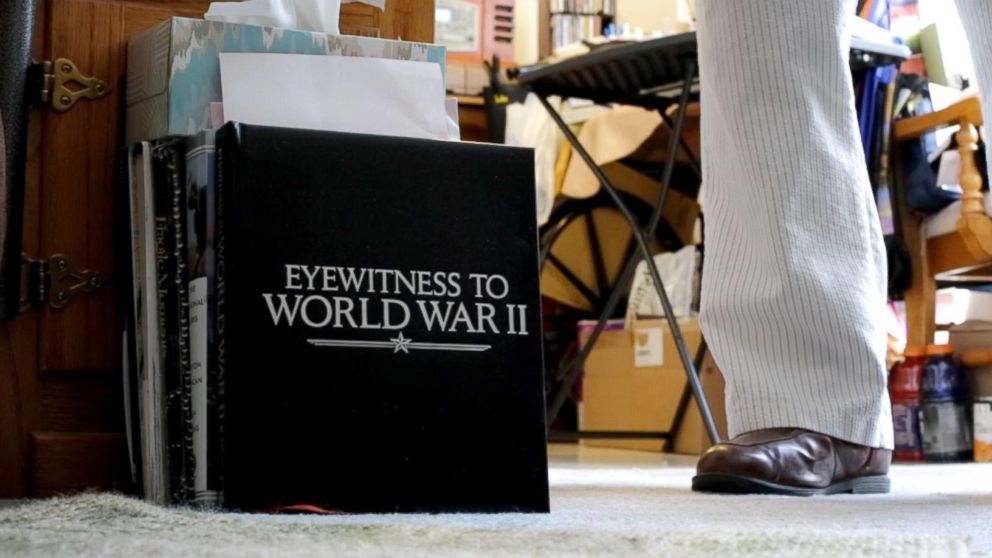 PHOTO: Leatherman stands next to a book on the ground of his apartment that is entitled "Witnesses of World War II". Leatherman was a mailman aboard the U.S.S. Oglethorpe in the Pacific Theater.