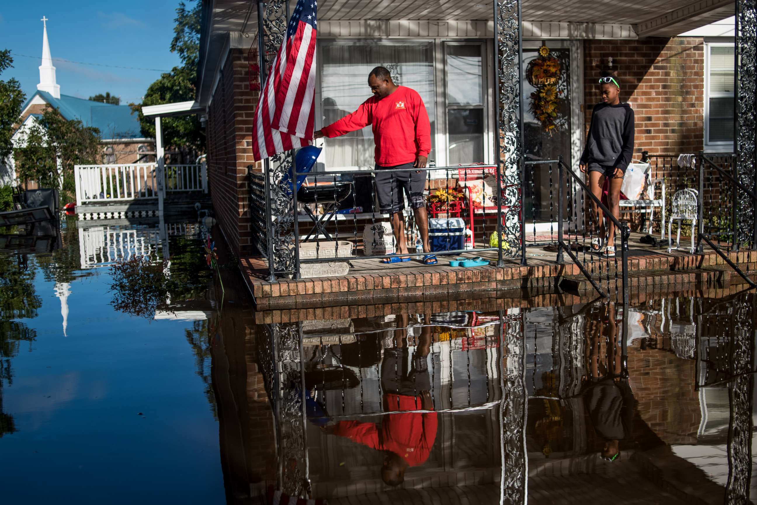 PHOTO: Robert Addison cooks breakfast on a charcoal grill with his son, Artis Addison, on Oct. 12, 2016 in a home surrounded by floodwater after Hurricane Matthew in Lumberton, N.C.