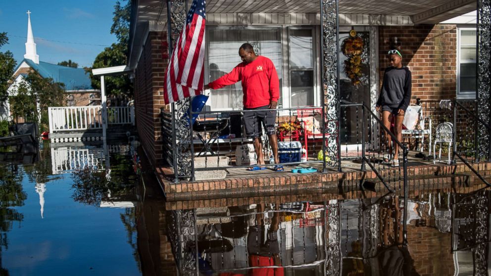 PHOTO: Robert Addison cooks breakfast on a charcoal grill with his son, Artis Addison, on Oct. 12, 2016 in a home surrounded by floodwater after Hurricane Matthew in Lumberton, N.C.