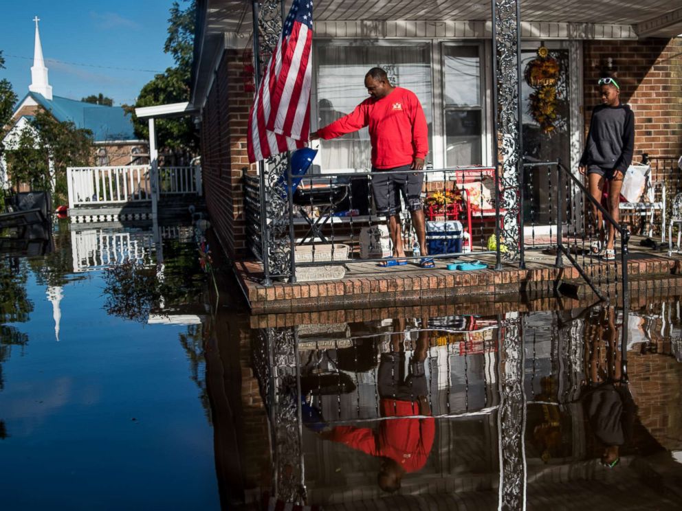 PHOTO: Robert Addison cooks breakfast on a charcoal grill with his son, Artis Addison, on Oct. 12, 2016 in a home surrounded by floodwater after Hurricane Matthew in Lumberton, N.C.