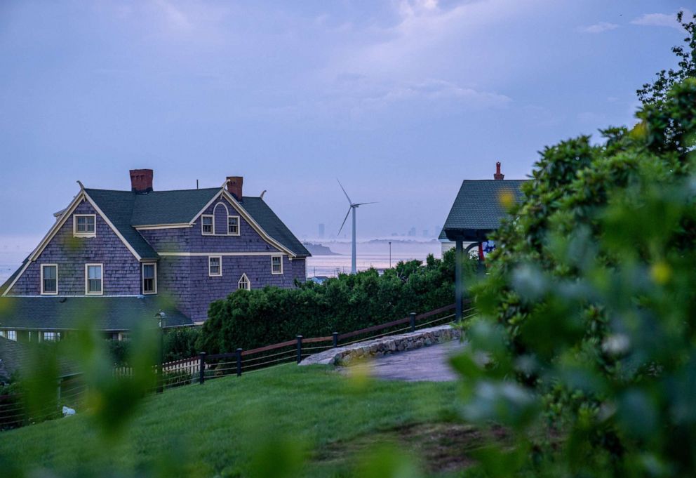 PHOTO: A Vestas wind turbine is visible between two residences, July 14, 2021, in Hull, Massachusetts.