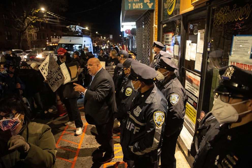 PHOTO: An attorney for the owner of the bar Louis Gerolmino, center, is seen outside of the Mac's Public House after closed it down amid the coronavirus disease (COVID-19) pandemic in Staten Island New York, Dec. 2, 2020.