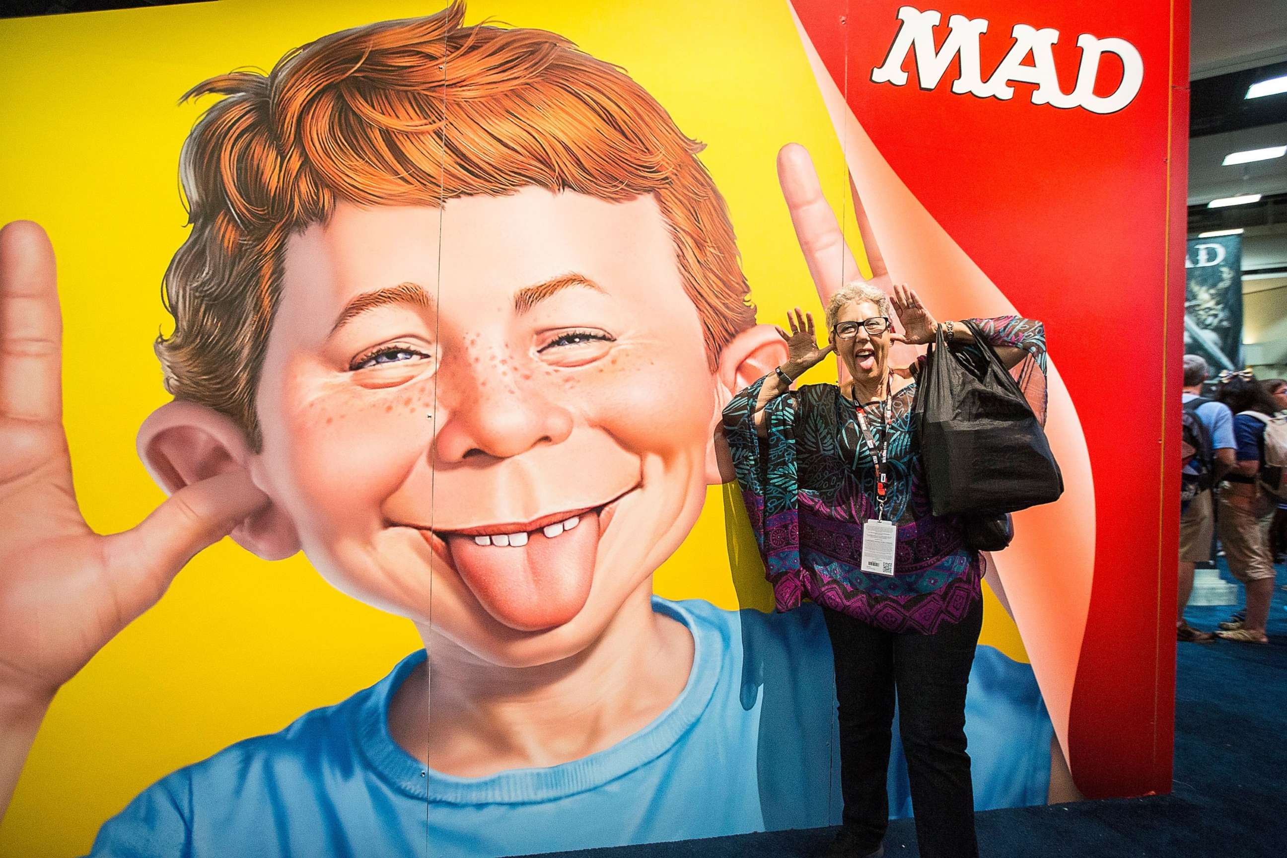 PHOTO: Attendee Judith Hawkins poses next to a display at the Mad Magazine booth at Comic-Con Preview Night on July 20, 2016 in San Diego, California.