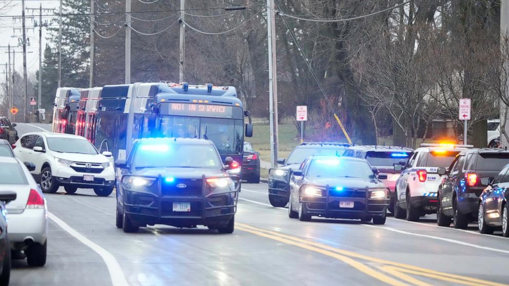 PHOTO: Bus carrying students leave as emergency vehicles are parked outside the Abundant Life Christian School in Madison, Wis., where multiple injuries were reported following a shooting, Dec. 16, 2024.