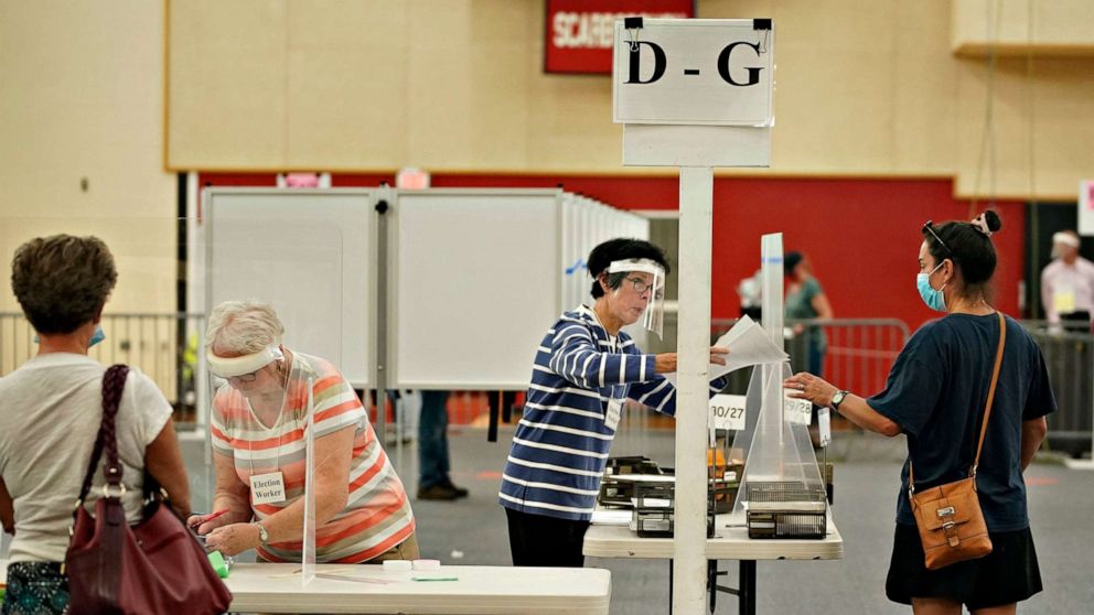 PHOTO: Election workers assist voters at Scarborough High School, July 14, 2020, in Scarborough, Maine.