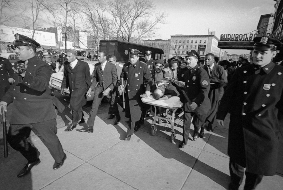 PHOTO: A policeman clears the way as Nationalist leader Malcolm X is carried from the Audubon Ballroom where he was fatally shot on Feb. 21, 1965.