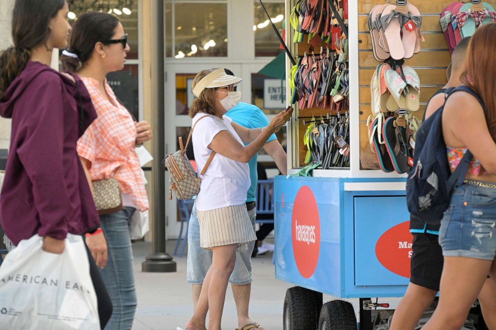 PHOTO: Some people wear face masks while shopping at the Orlando Vineland Premium Outlets shopping mall on July 12, 2022, in Orlando, Fla.