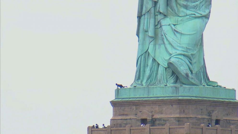 A woman appears to be climbing up the Statue of Liberty, July 4, 2018 in New York.