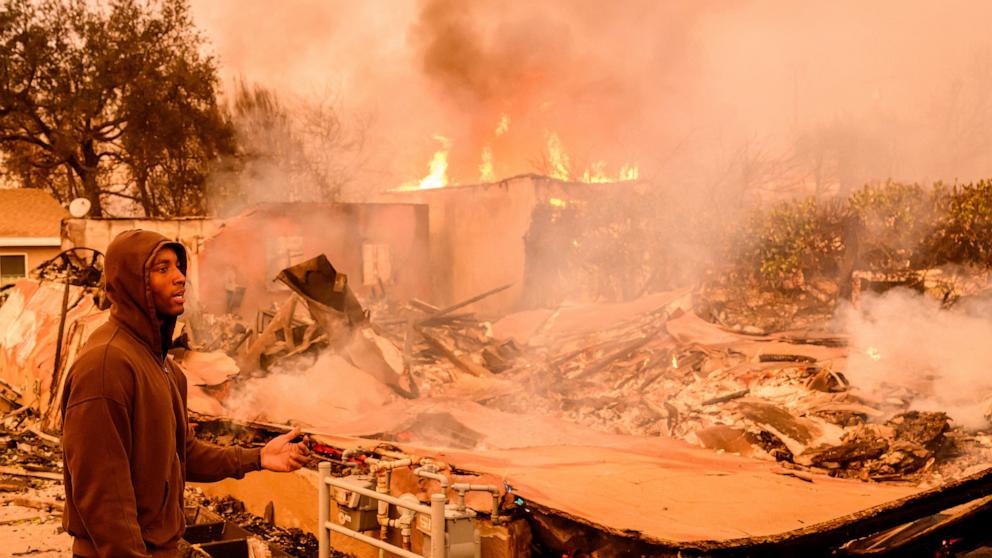 PHOTO: A resident views his property as it burns during the Eaton fire in the Altadena area of Los Angeles County, Calif., Jan. 8, 2025. 