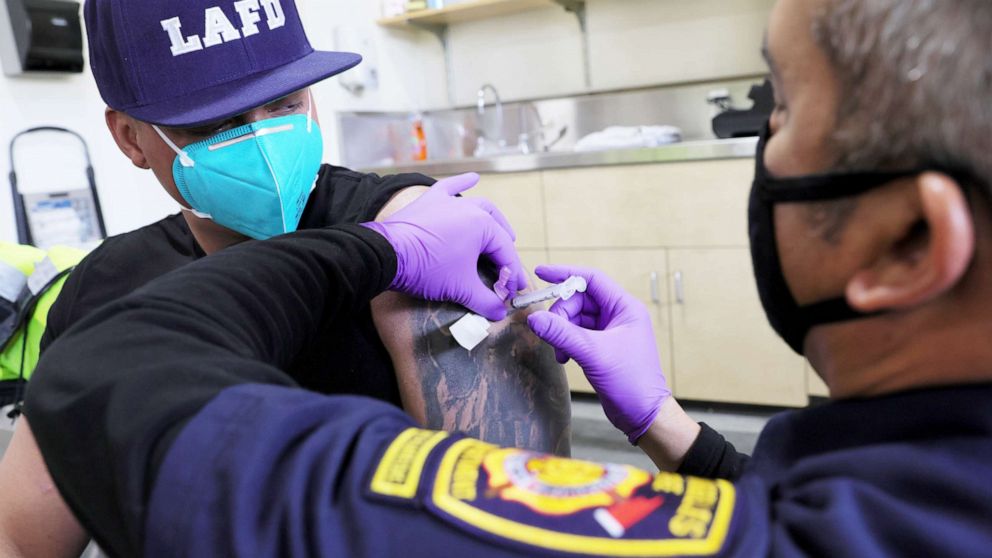 PHOTO: A Los Angeles Fire Department firefighter receives a COVID-19 vaccination dose from firefighter paramedic Alexander Gorme at a fire station in Los Angeles, Jan. 29, 2021.