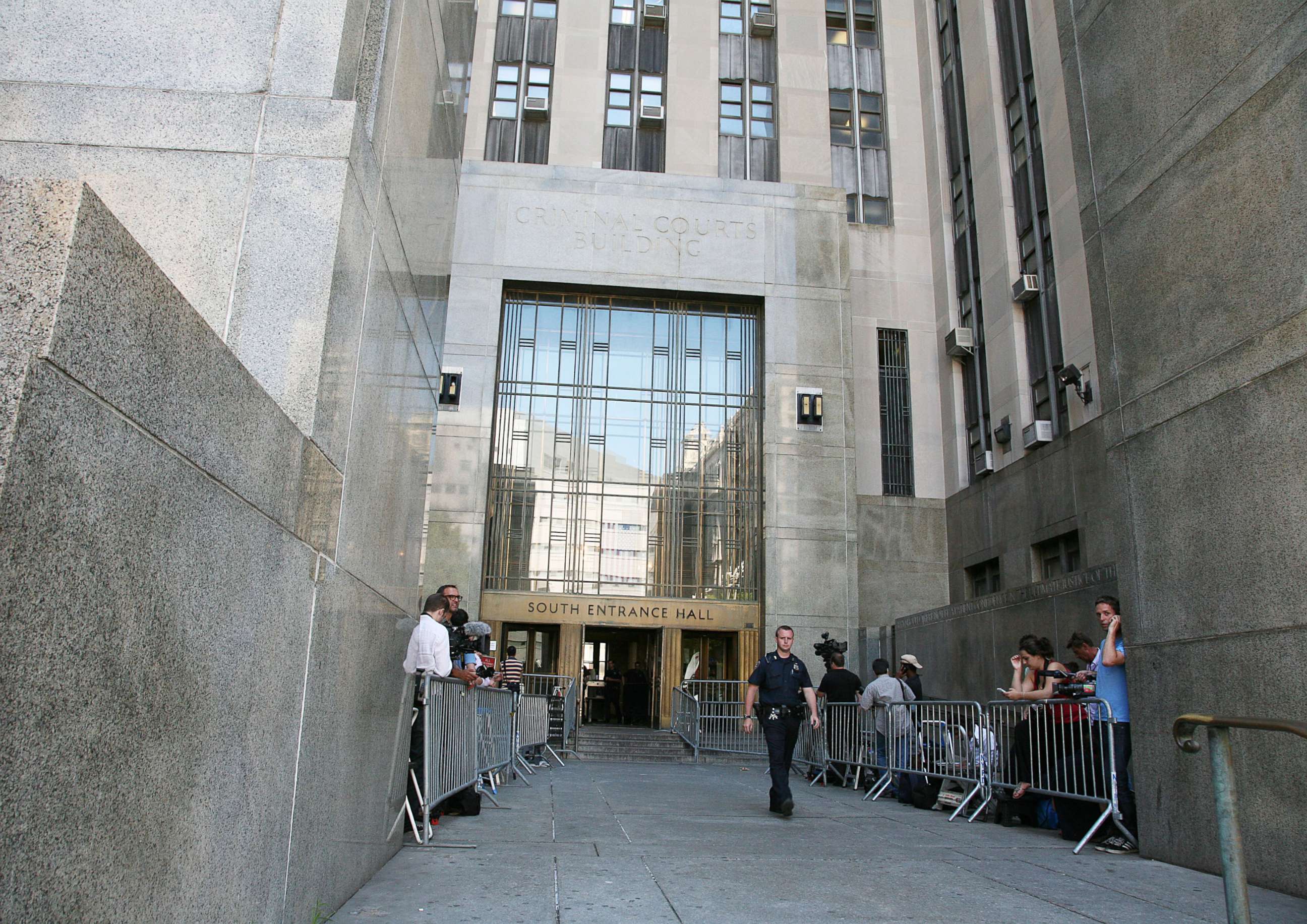 PHOTO: People stand behind barriers outside Manhattan Criminal Court on July 1, 2011, in New York.