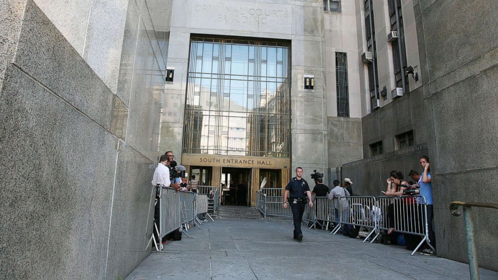 PHOTO: People stand behind barriers outside Manhattan Criminal Court on July 1, 2011, in New York.
