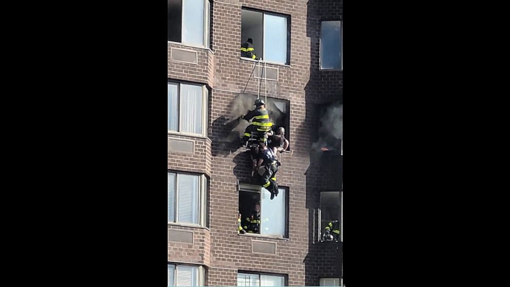 PHOTO:  A woman is rescued by NYFD firemen in an image taken from video posted to Twitter, after a fire in a Midtown Manhattan high-rise trapped residents in the morning of Nov.5, 2022, leaving several people injured, according to the FDNY.