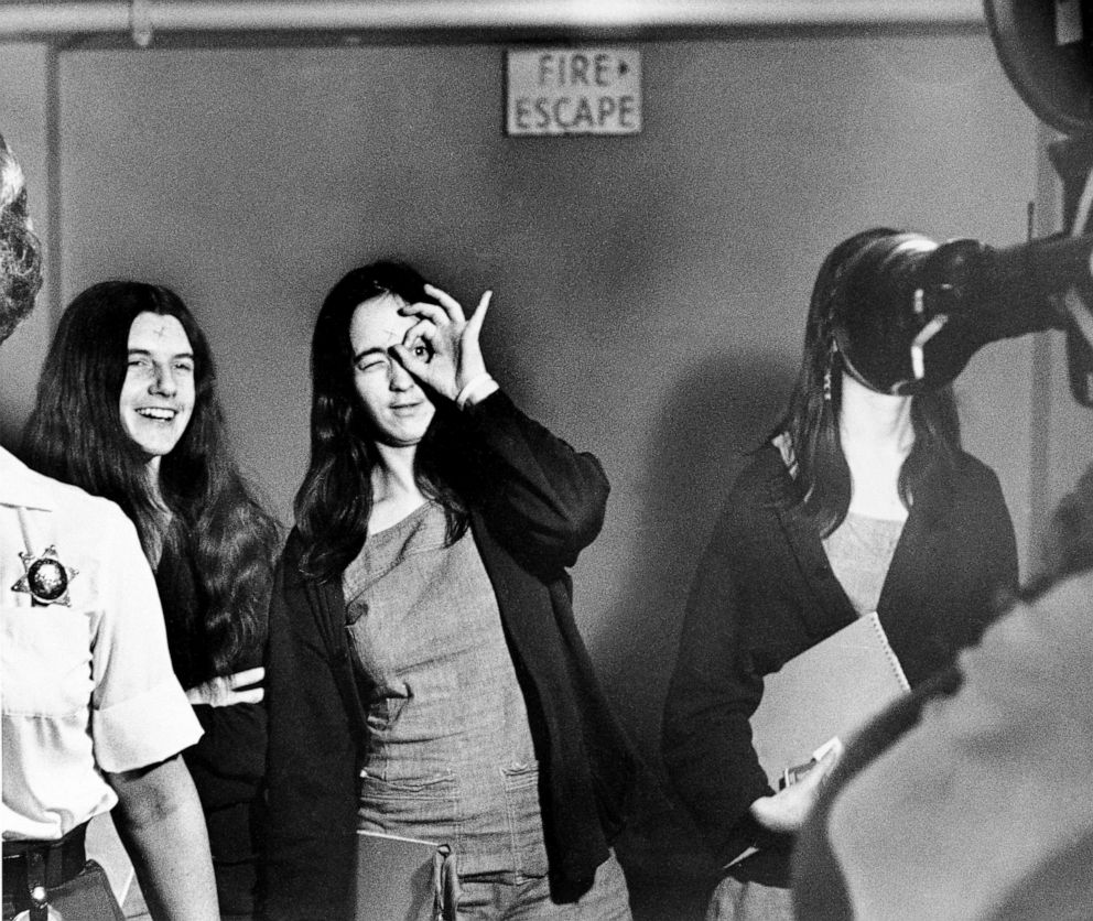 PHOTO: Susan Denise Atkins, defendant in the Tate murder trial, mimics a television film cameraman while on her way to court in Los Angeles with fellow defendants Patricia Krenwinkel, left, and Leslie Van Houten, hidden by the camera lens, Sept. 22, 1970.