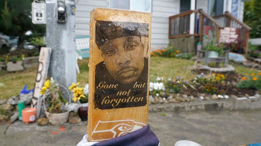 PHOTO: A sign that reads "gone but not forgotten" is shown on a cross displayed at a makeshift memorial on May 27, 2021, at the intersection in Tacoma, Washington, where Manuel "Manny" Ellis" died after he was restrained by police on March 3, 2020.