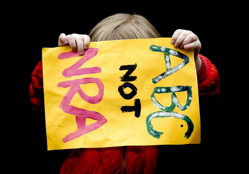 PHOTO: A young demonstrator holds a sign which says 'ABC not NRA' during a rally calling for stronger gun control in the United States at the Museumsquare in Amsterdam, March 24, 2018.