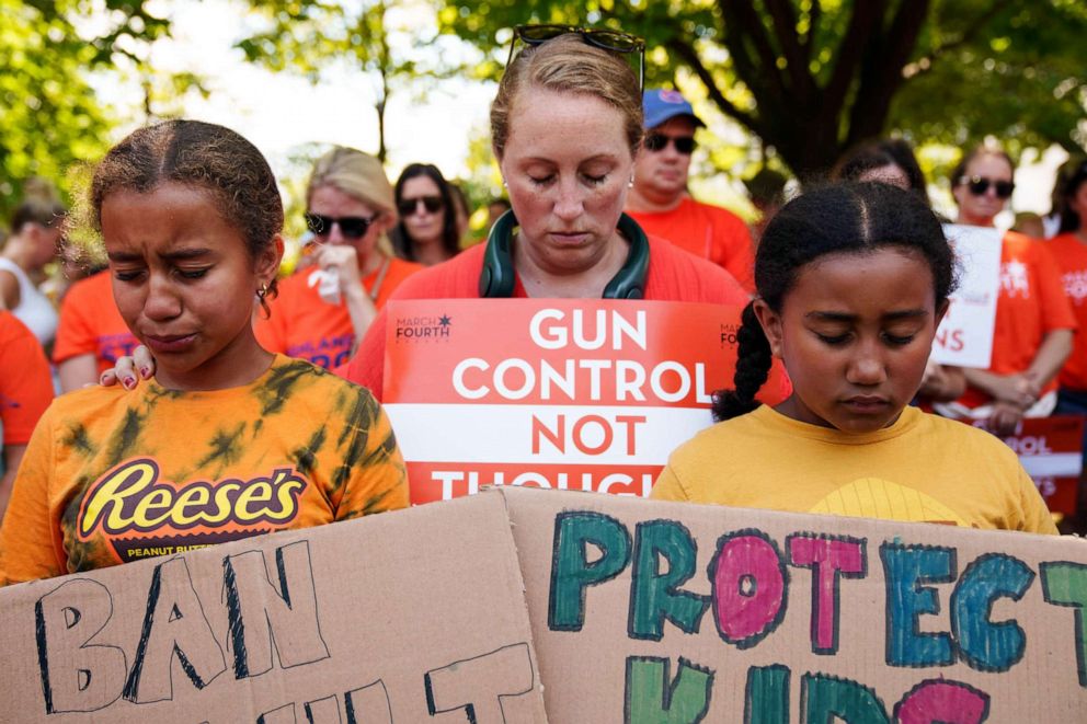 PHOTO: Lindsey Harper of Bethesda, with her daughters Vivienne and Reese, participate in a moment of silence during a rally at the U.S. Capitol, July 13, 2022.