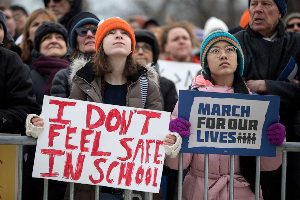 PHOTO: Madeline Pollock, left, 14, and Lena Brockway, 15, hold signs as thousands gather in Union Park for the March for our Lives protest, March 24, 2018, in Chicago.