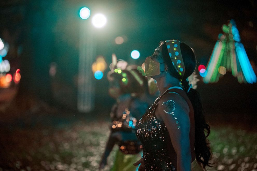 PHOTO: Dancers in the Roux La La krewe perform for vehicles driving by during the Mardi Gras Float in the Oaks event in City Park, Feb. 14, 2021, in New Orleans, Louisiana.