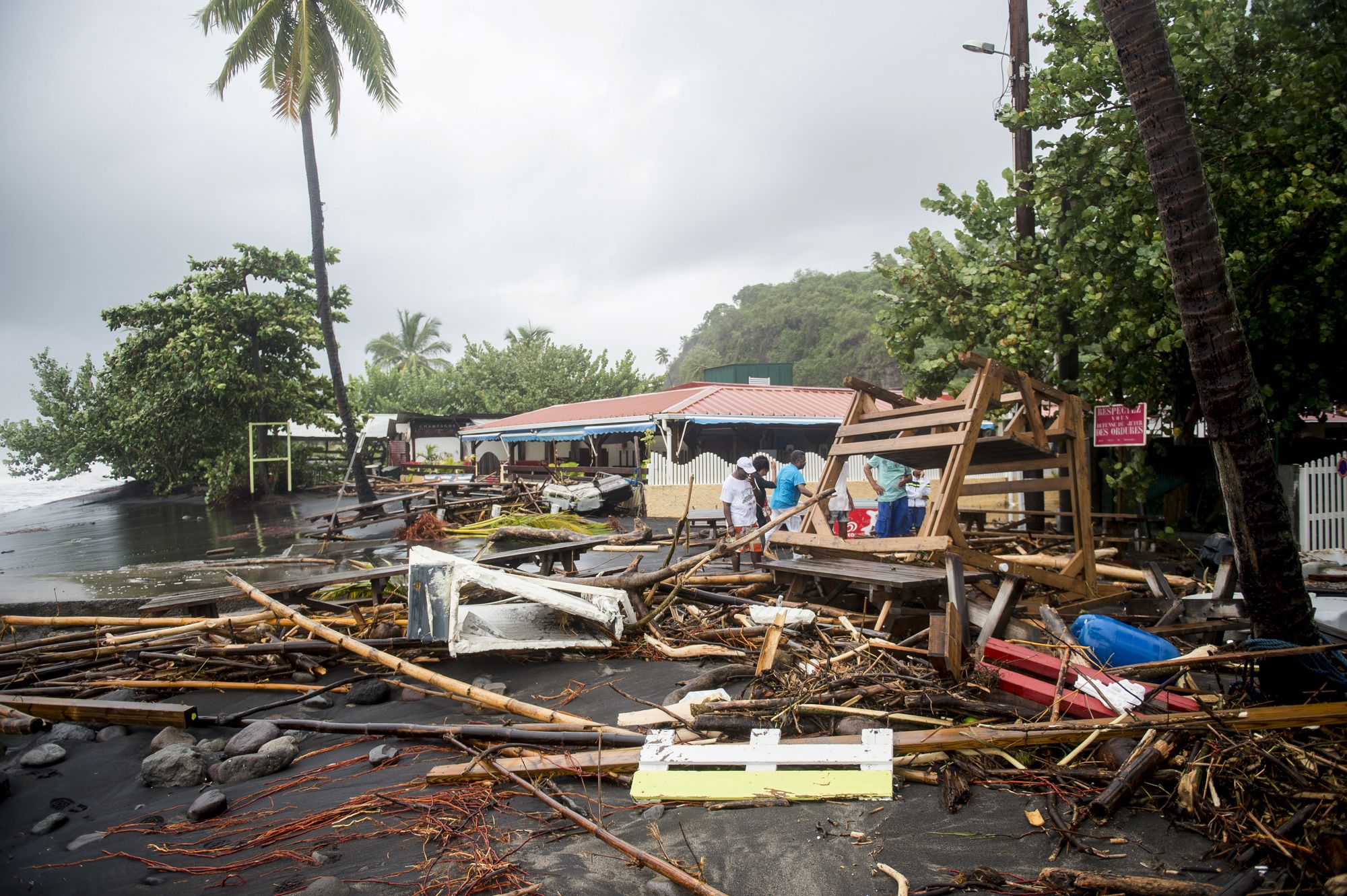 PHOTO: People stand among the debris at a restaurant in Le Carbet, on the French Caribbean island of Martinique, after it was hit by Hurricane Maria, on September 19, 2017.
