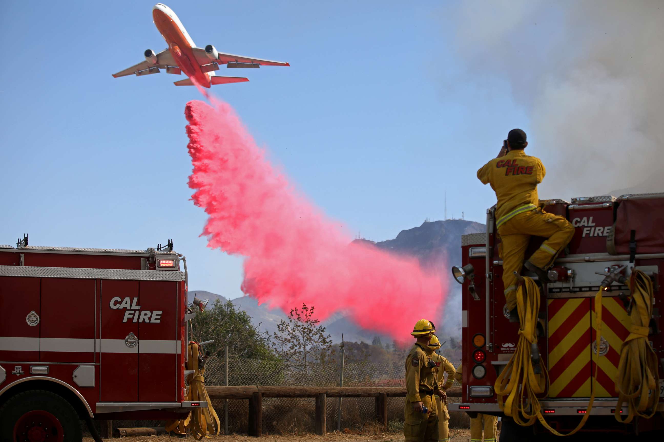 PHOTO: Cal Fire firefighters look on as a plane drops fire retardant on the Maria Fire in Santa Paula, California, U.S. November 1, 2019.