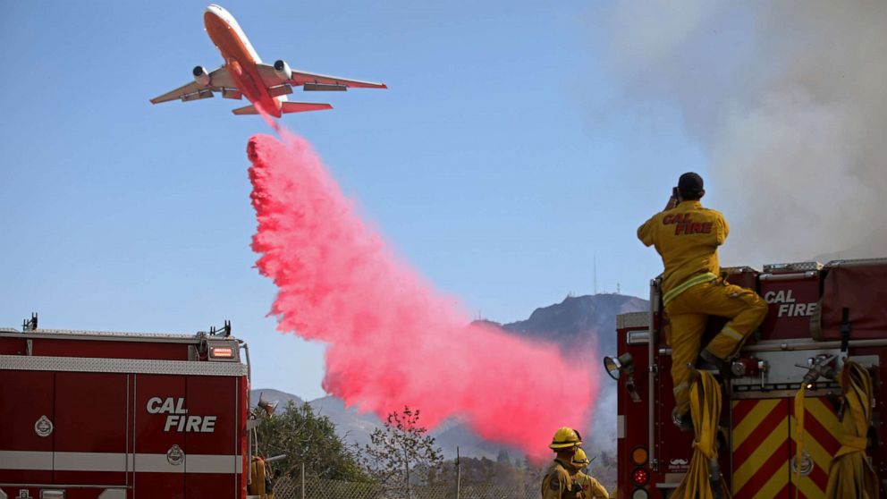 PHOTO: Cal Fire firefighters look on as a plane drops fire retardant on the Maria Fire in Santa Paula, California, U.S. November 1, 2019.
