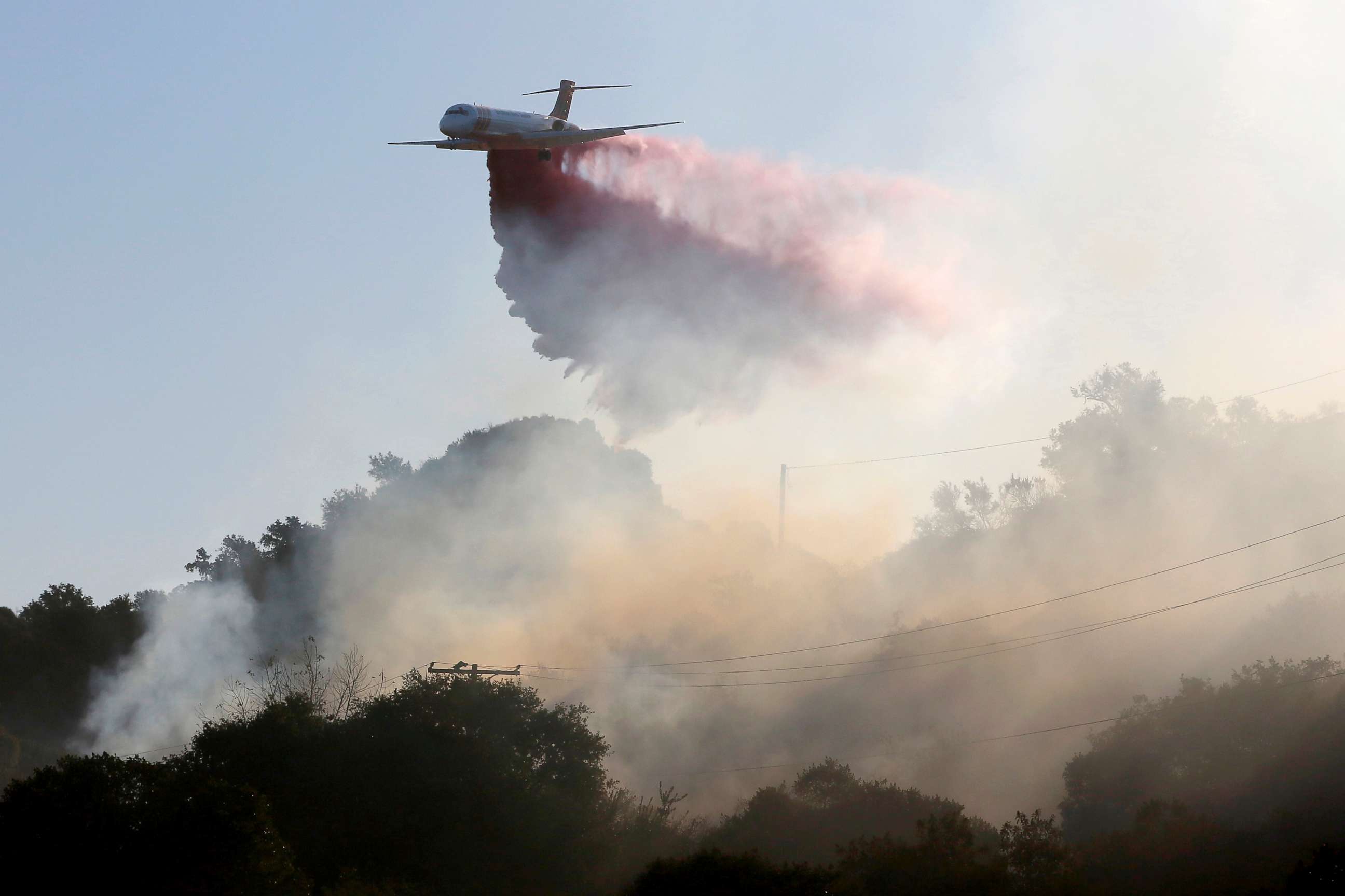 PHOTO: A plane drops fire retardant on the Maria Fire in the early morning in Santa Paula, Calif., Nov. 1, 2019. 