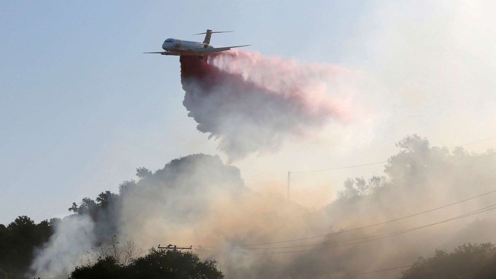 PHOTO: A plane drops fire retardant on the Maria Fire in the early morning in Santa Paula, Calif., Nov. 1, 2019. 