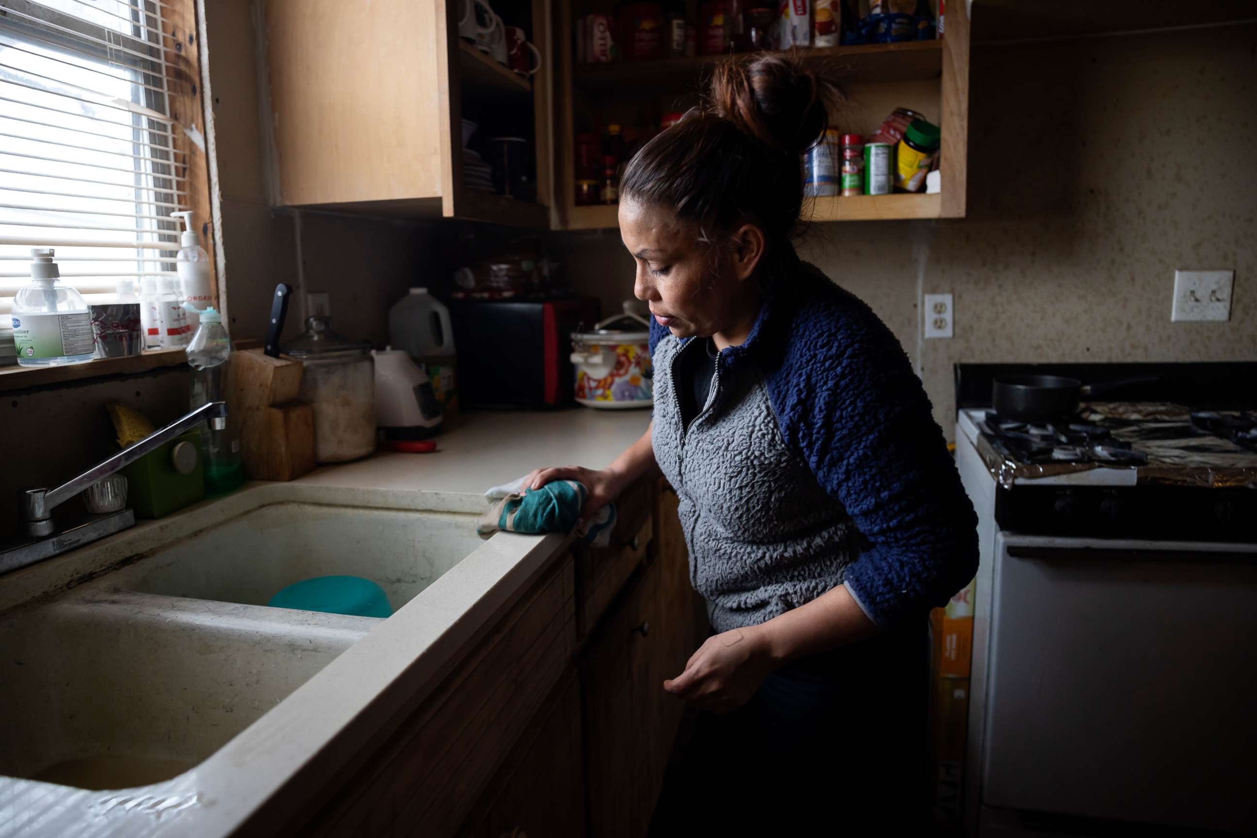 PHOTO: Maria Pineda cleans the kitchen of a home, where she temporarily stays, Feb. 18, 2021, in Conroe, Texas.