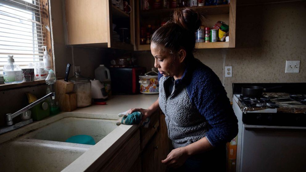 PHOTO: Maria Pineda cleans the kitchen of a home, where she temporarily stays, Feb. 18, 2021, in Conroe, Texas.