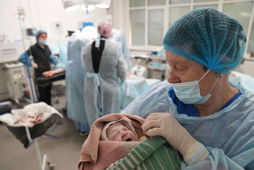 A medical worker holds a newborn girl, Alana, after cesarian section in a hospital in Mariupol, Ukraine, March 11, 2022. Alana's mother had to be evacuated from another maternity hospital that was destroyed and lost some of her toes after the attack.