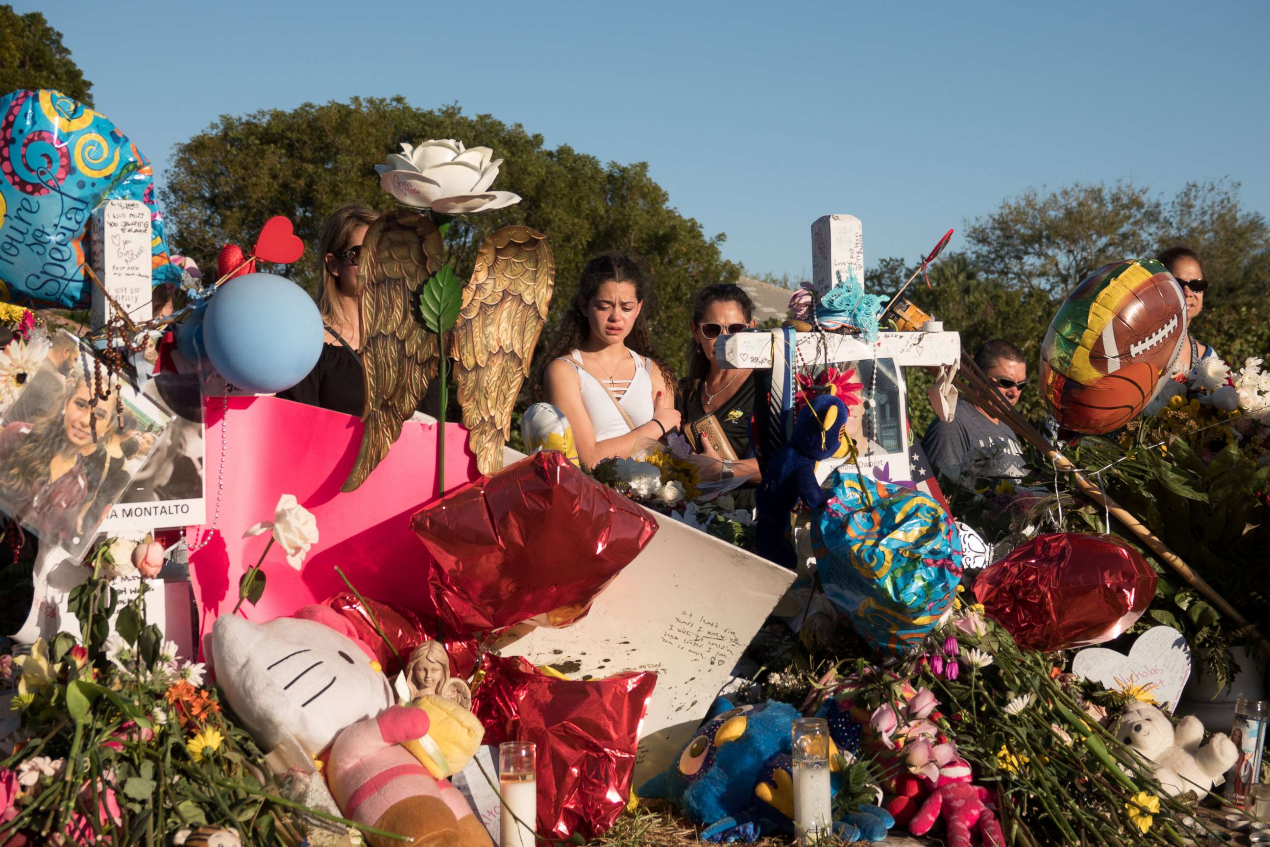 PHOTO: People are pictured at a memorial the day students and parents arrive for voluntary campus orientation at the Marjory Stoneman Douglas High School following last week's mass shooting in Parkland, Fla., Feb. 25, 2018.
