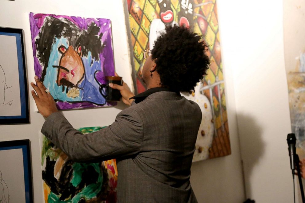 PHOTO: Mark West hangs up one of Princess' three paintings in The House of Mark West Gallery. West, 24, opened a gallery space for black and brown artists in the Bronx.
